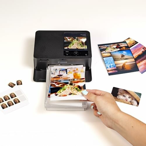 Photo printer with printed images and hand taking a photo