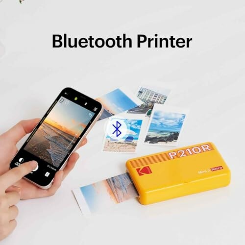 Portable Bluetooth printer with smartphone and printed photos.