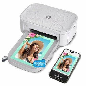 Portable photo printer with smartphone displaying a photo.